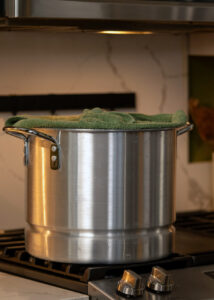 A tamale pot on the stove, steaming tamales