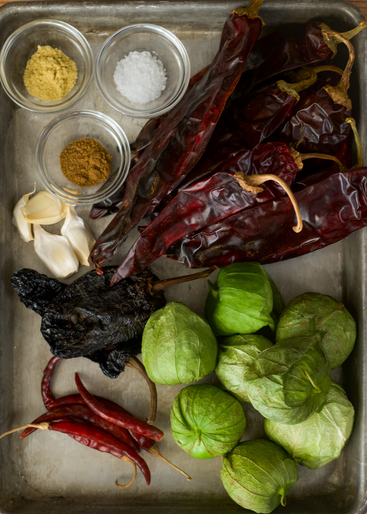 Salsa roja ingredients- dried red chilis, green tomatillos, garlic, and seasonings