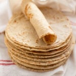 stack of corn tortillas and one rolled up without any cracks