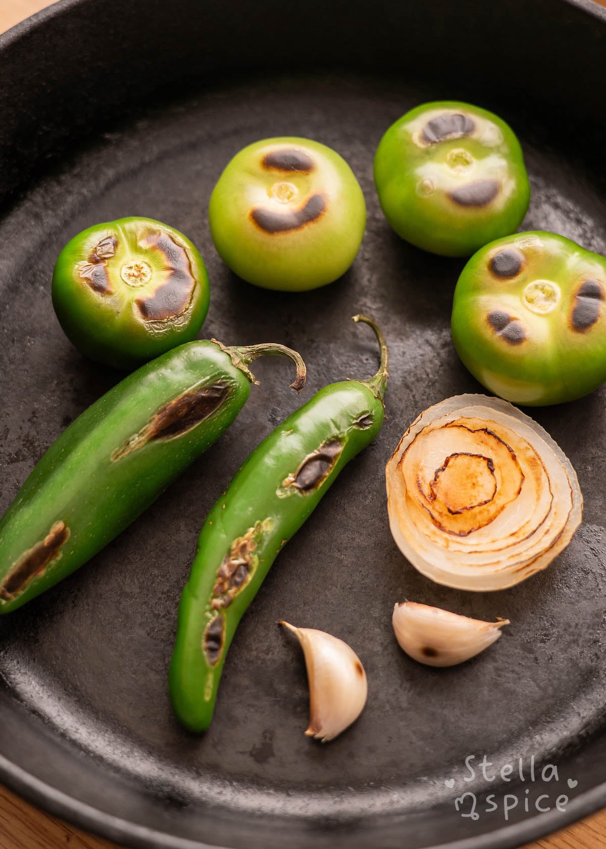 tomatillos, garlic, onion, and serrano peppers charred in a skillet