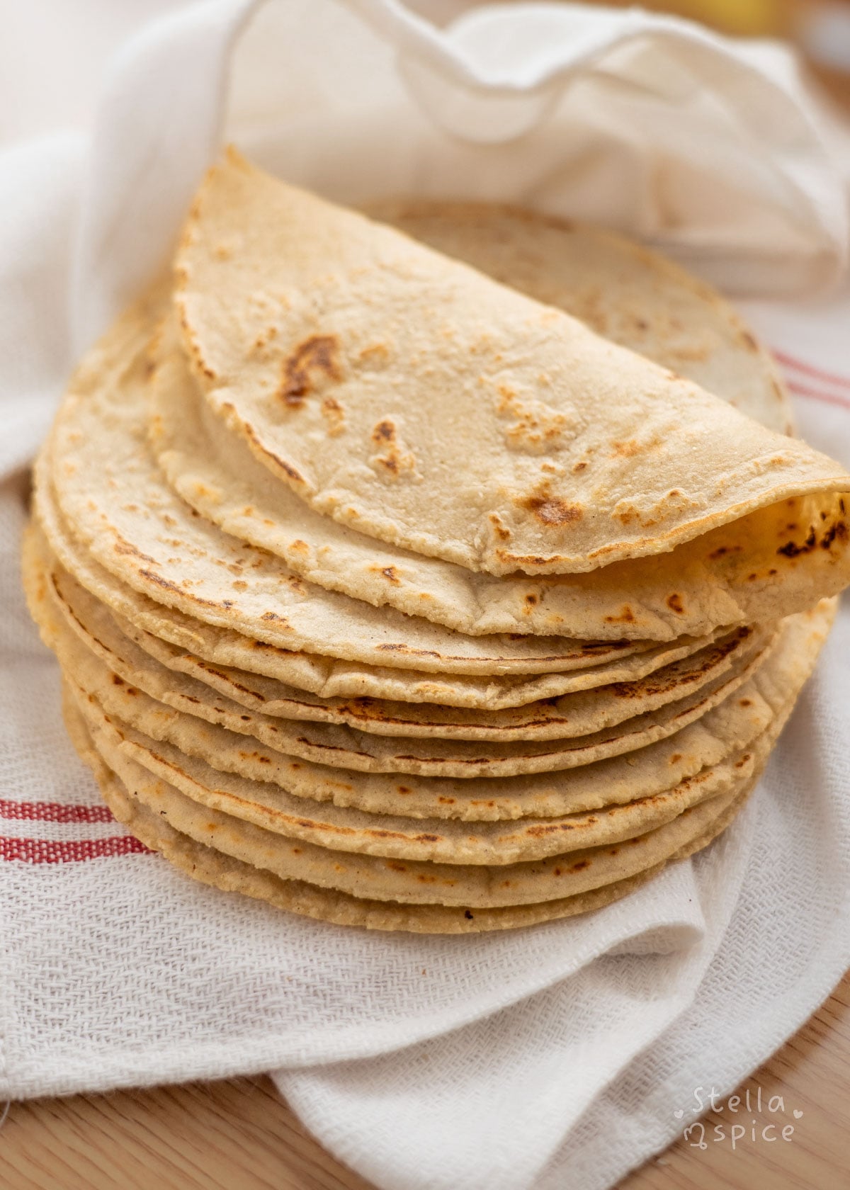 stack of corn tortillas with one folded on top.